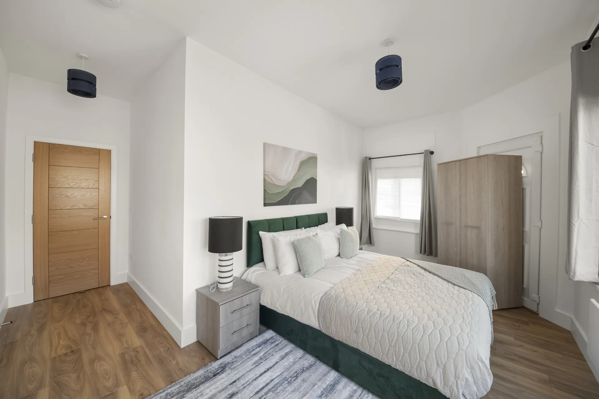 A bedroom with fitted wardrobe and lined curtains