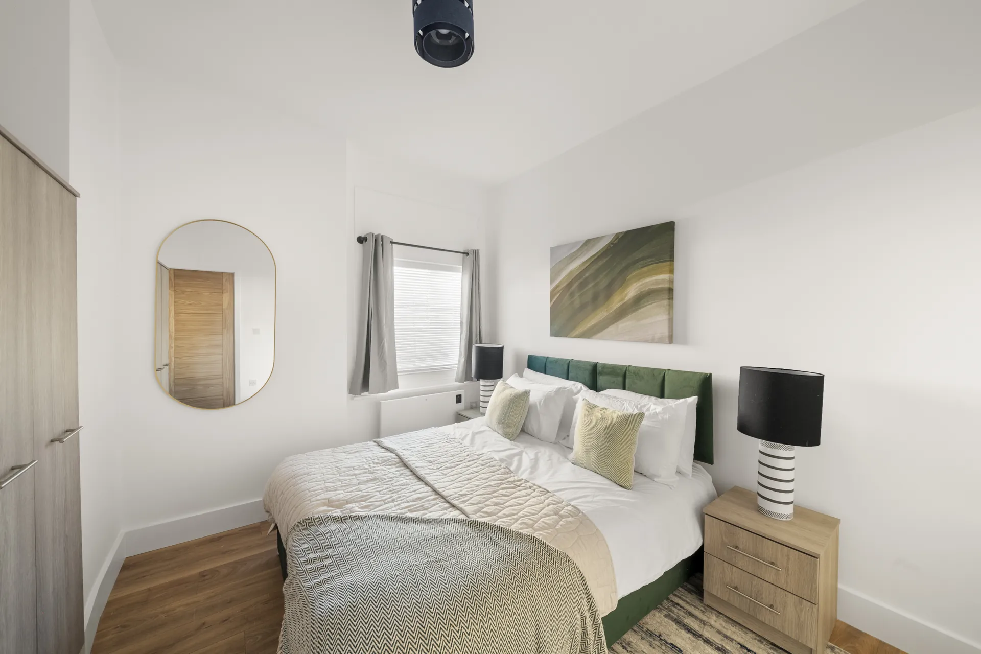 Deep velvet headboard, bedside tables and a reading lamp either side