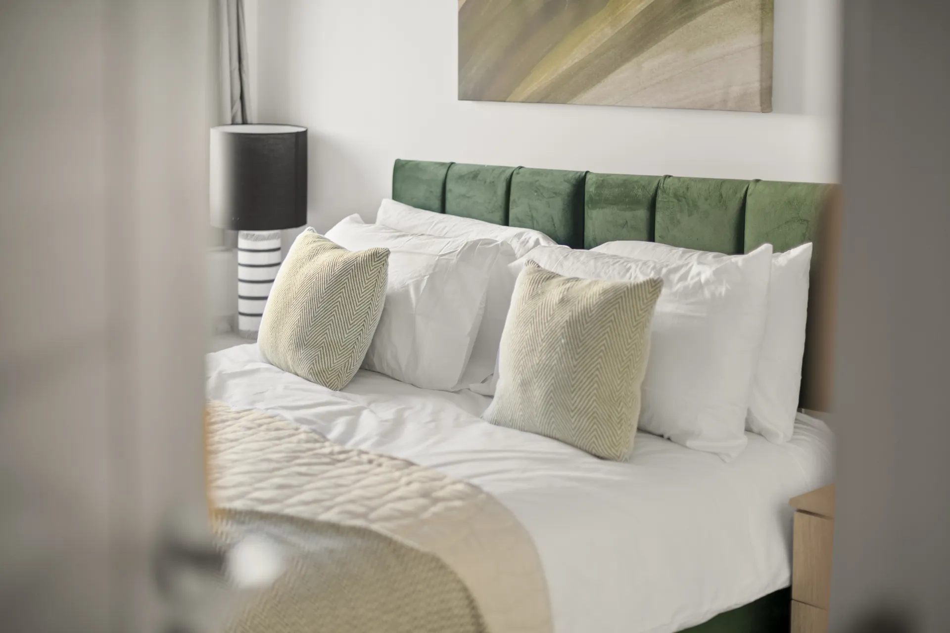 Cushions and a throw over freshly pressed white cotton