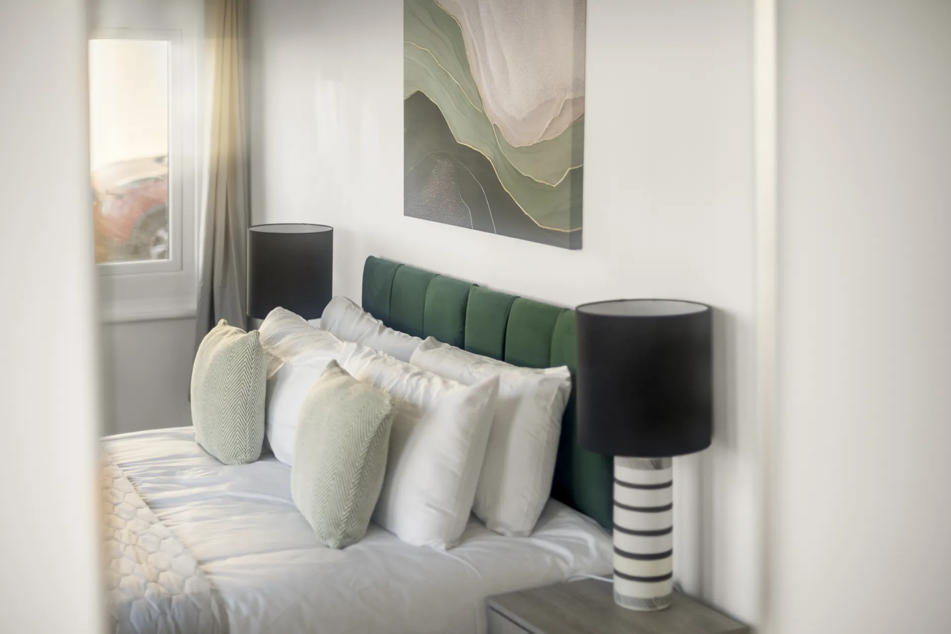 Bedside lamps and original artwork above the bed