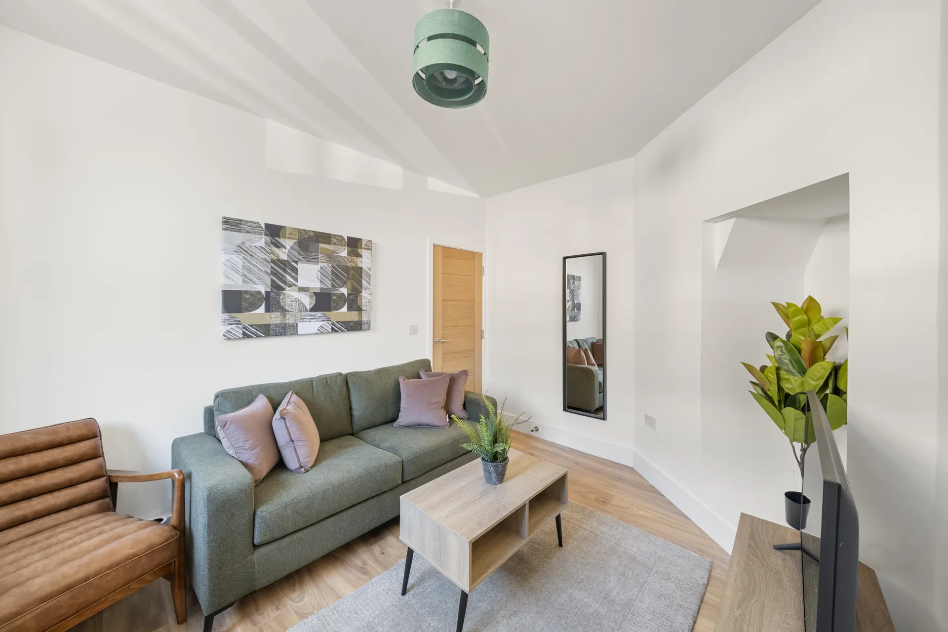 The living room, with a deep three-seat sofa, leather armchair and room to spread out