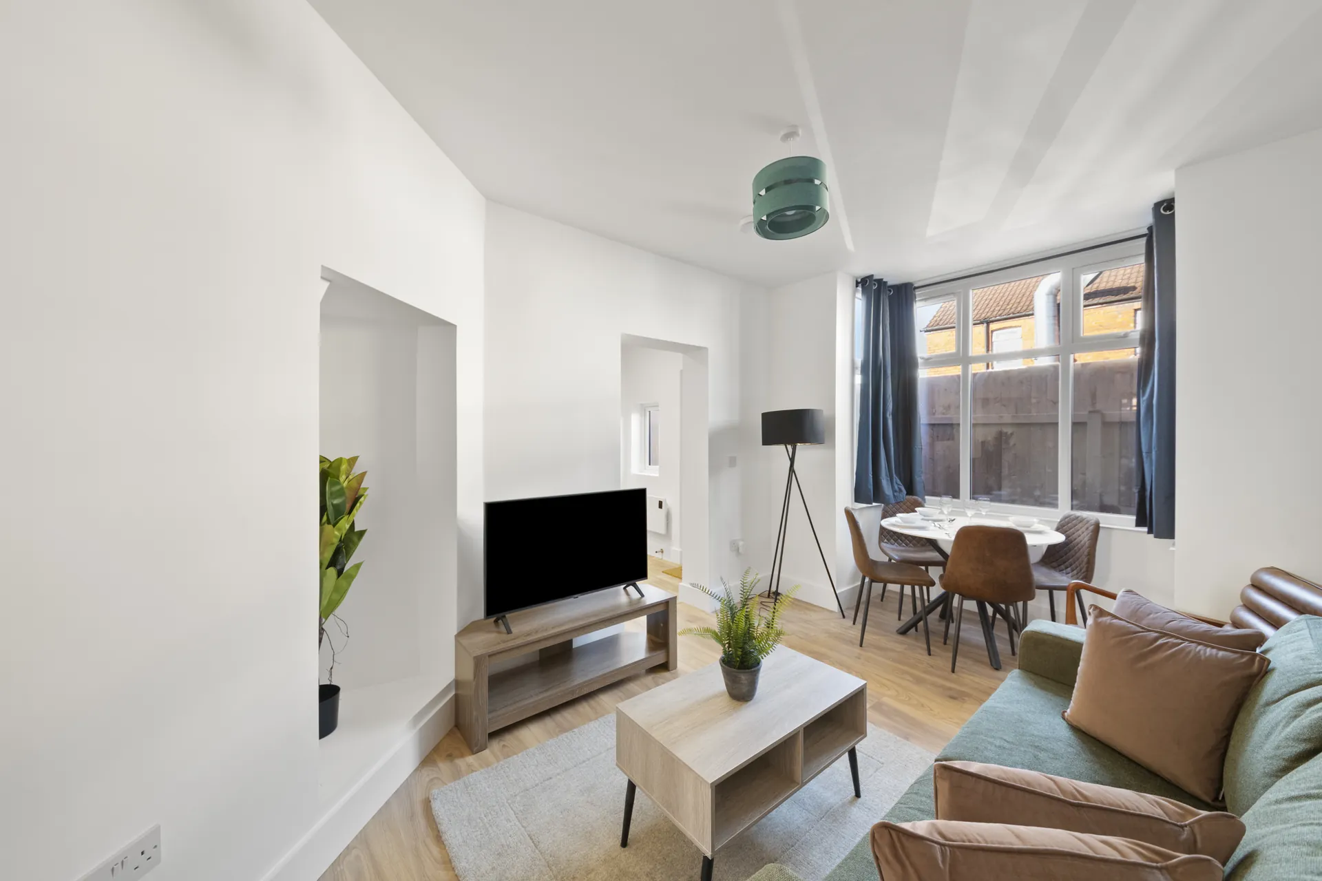Smart TV, coffee table and dining for four in one bright, open room
