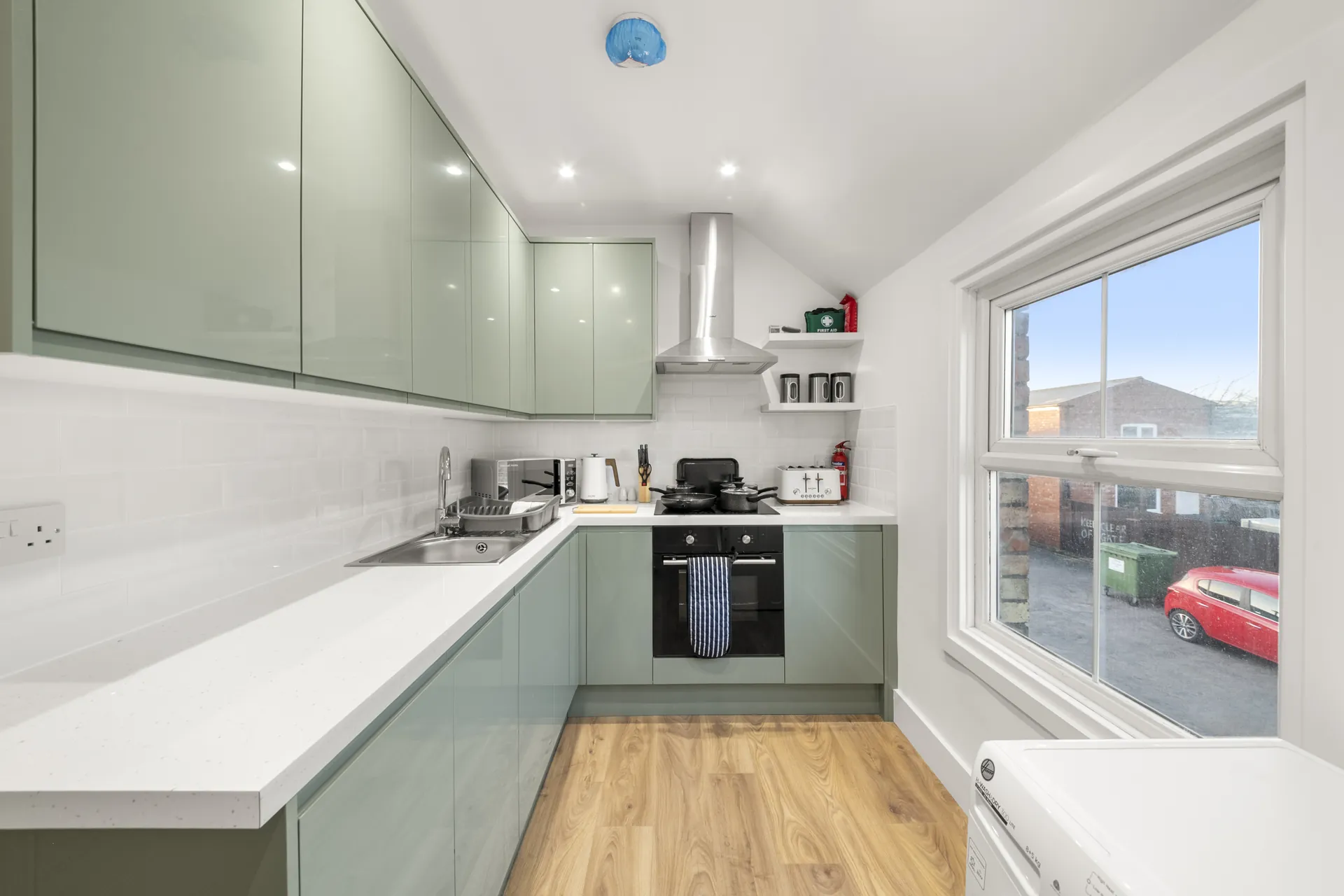 Sage-green units with a window over the worktop