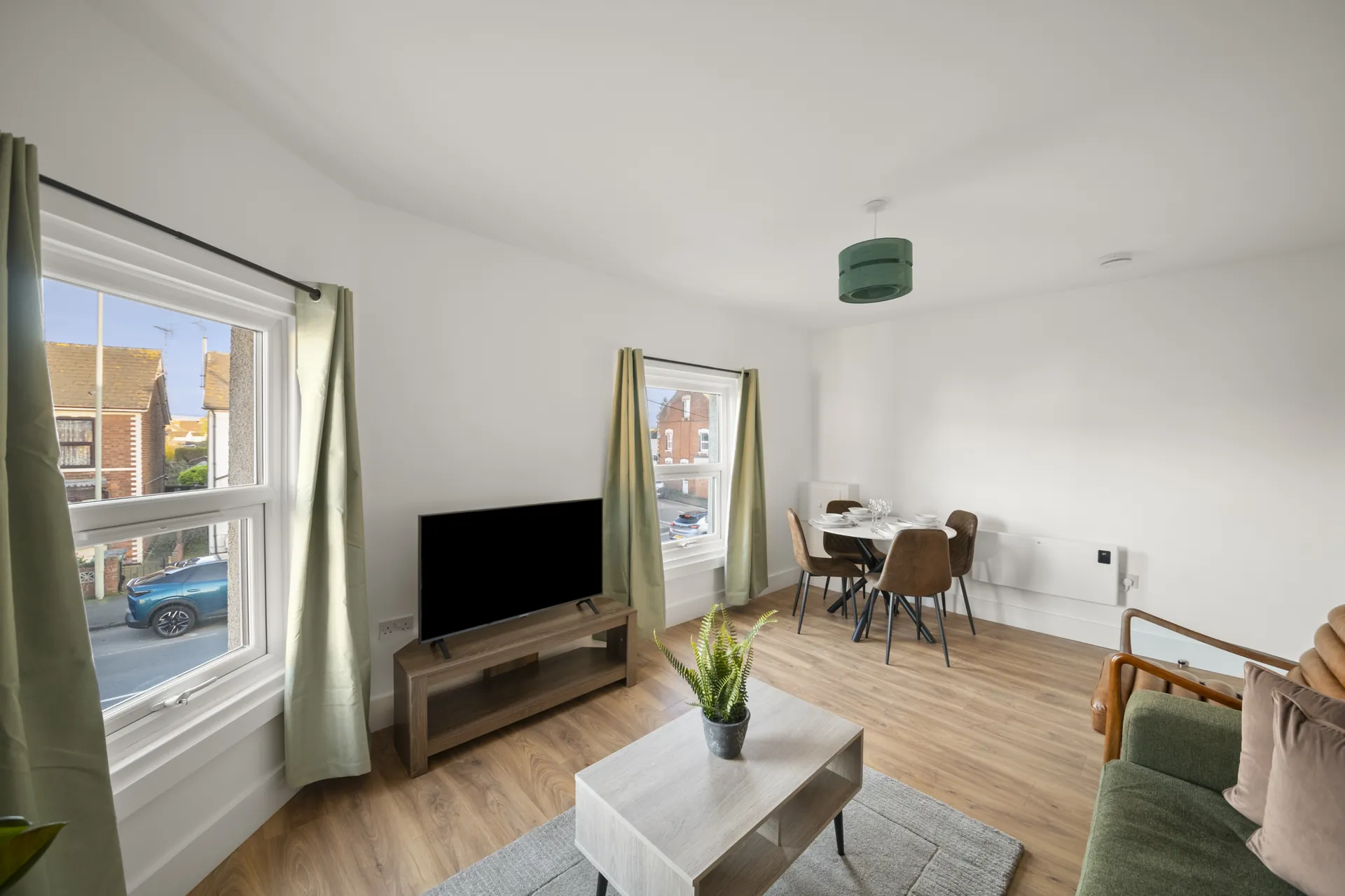 Smart TV, sofa and dining table beneath the front window